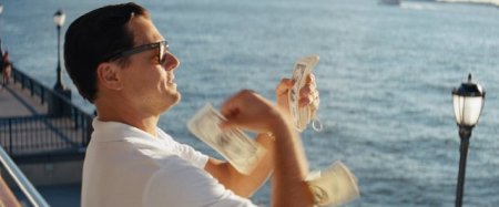 Jordan Belfort (Leonardo DiCaprio), "The Wolf of Wall Street," throws money down to bribe an FBI agent, in a moment of crass desperation.