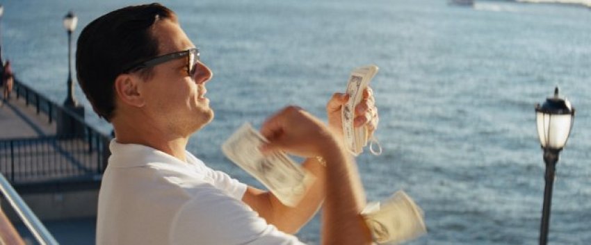 Jordan Belfort (Leonardo DiCaprio), "The Wolf of Wall Street," throws money down to bribe an FBI agent, in a moment of crass desperation.