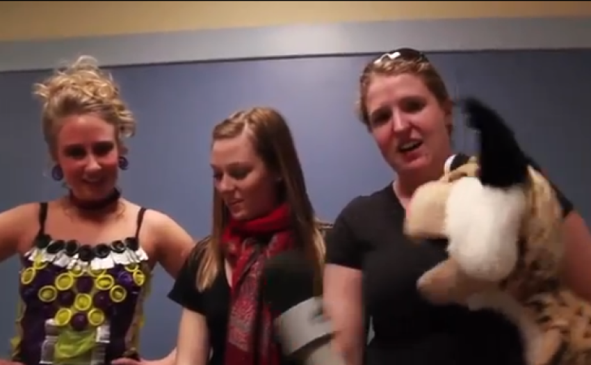 A student wearing condoms attached to lingerie is being interviewed by a puppet at Montana State University's third annual