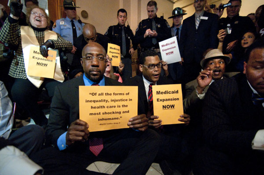 Rev. Raphael Warnock, a pastor at Ebenezer Baptist Church, Rev. Martin Luther King Jr.'s old church, holds a sign that quotes the former civil rights icon: 