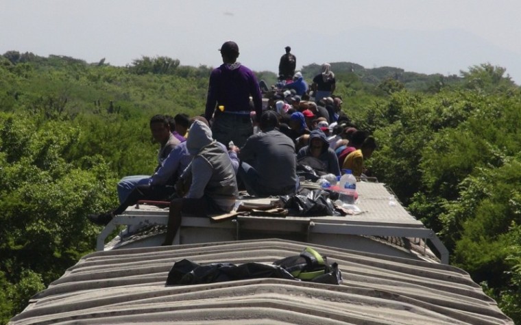 Unaccompanied minors ride atop the wagon of a freight train, known as La Bestia (The Beast) in Ixtepec, in the Mexican state of Oaxaca, June 18, 2014. | Reuters/Jose de Jesus Cortes