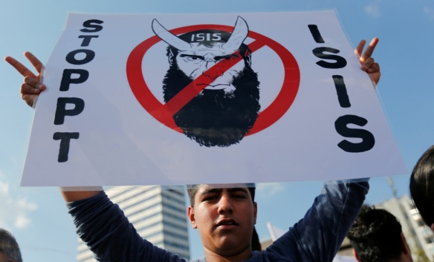 A Kurd of the ethnic minority of Yazidis holds up a placard reading "Stop IS" during a demonstration in Bielefeld, Aug. 9, 2014. Some 10,000 ethnic Kurds of the Yazidis sect, who practice an ancient faith related to Zoroastrianism, protested in the western German city on Saturday against Islamic State militants, who are surging across northern Iraq near the Kurdistan borders in their drive to eradicate unbelievers such as Christians and Yazidis.