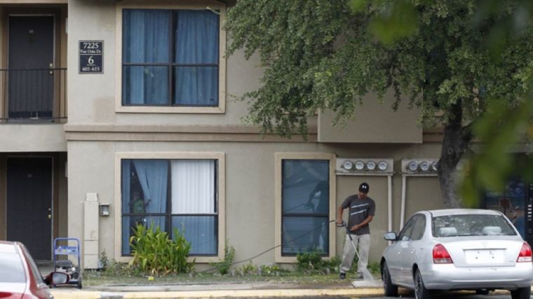 A worker power washes the sidewalk in front of the apartment unit at The Ivy Apartments where a man diagnosed with the Ebola virus was staying in Dallas, Texas October 2, 2014.