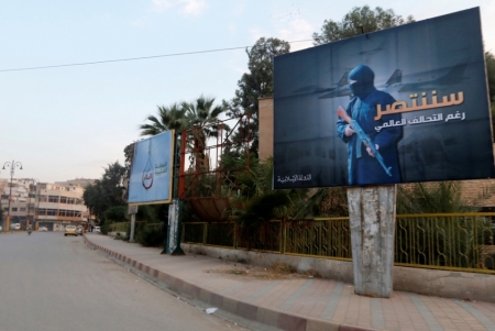 Islamic State billboards are seen along a street in Raqqa, eastern Syria, which is controlled by the Islamic State, October 29, 2014. The billboard (R) reads: "We will win despite the global coalition."