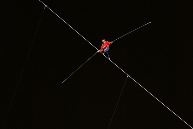 Daredevil Nik Wallenda walks along a tightrope between two skyscrapers suspended 500 feet (152.4 meters) above the Chicago River in Chicago, Illinois, November 2, 2014.