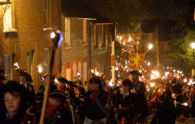 Participants in costume hold burning torches and crosses as they take part in one of a series of processions during Bonfire night celebrations in Lewes, southern England November 5, 2013. The processions and bonfire mark the uncovering of Guy Fawkes'