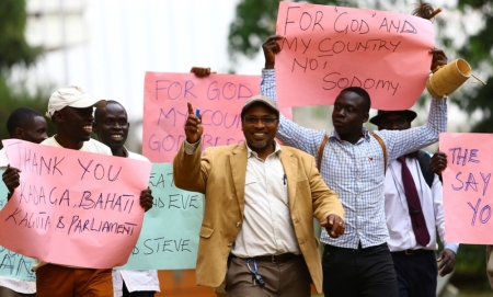 Ugandan anti-homosexuality activist pastor Martin Ssempa (C) leads supporters as they celebrate after Uganda's President Yoweri Museveni signed a bill into law that strengthened existing punishments, such as imposing jail terms of up to life for
