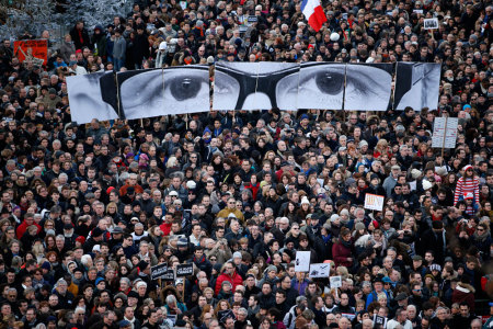 People hold panels to create the eyes of late Charlie Hebdo editor Stephane Charbonnier, known as
