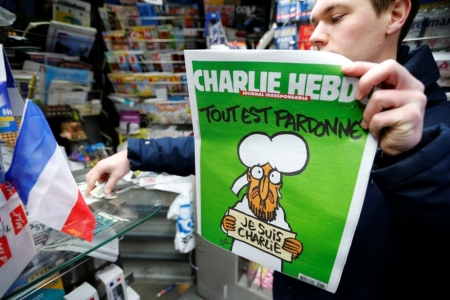 A man holds the new issue of satirical French weekly Charlie Hebdo entitled