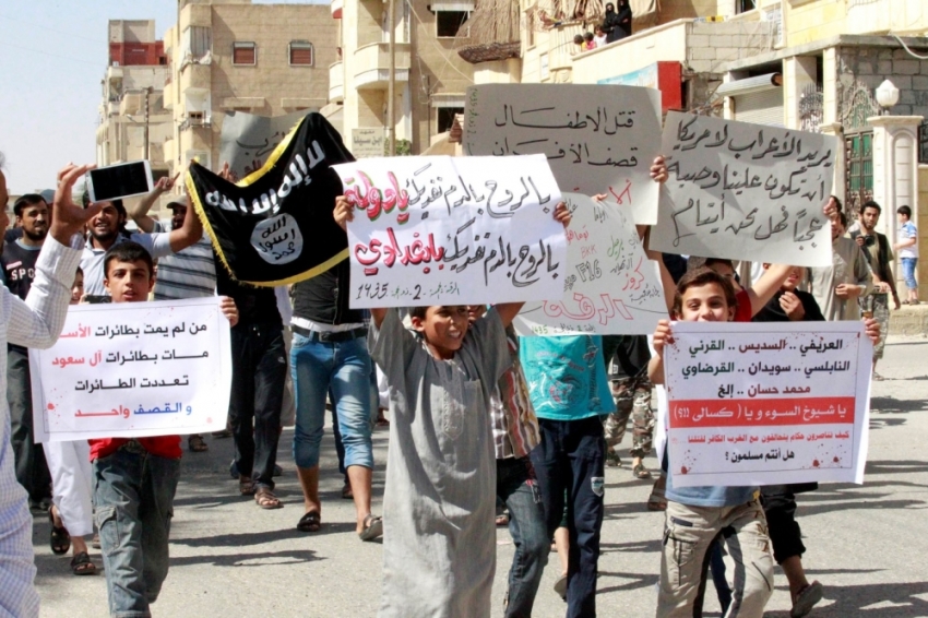 Youths carry banners during a protest against the U.S. airstrikes on the Islamic State (IS) in Raqqa September 26, 2014. The banners in Arabic read, 