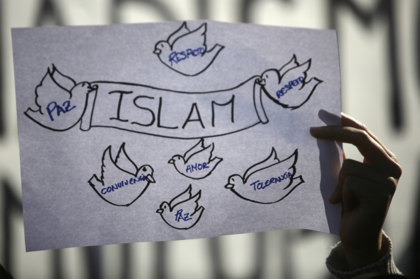 A girl holds up a sign during a rally by members of the Muslim community of Madrid outside Madrid's Atocha train station, January 11, 2015, in solidarity with the victims of a shooting by gunmen at the Paris offices of the satirical weekly newspaper Charlie Hebdo, and against Islamophobia.