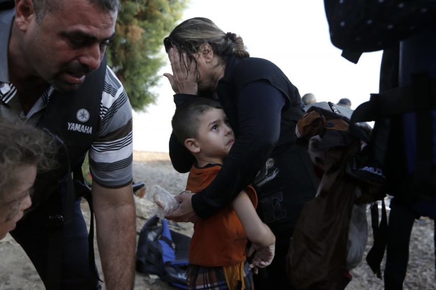 A Syrian boy is hugged by his mother moments after they arrived at a beach on the Greek island of Kos after crossing a part of the Aegean sea from Turkey to Greece, August 15, 2015. The United Nations refugee agency called on Greece to take control of the "total chaos" on Mediterranean islands, where thousands of migrants have landed. About 124,000 have arrived this year by sea, many via Turkey, according to Vincent Cochetel, UNHCR director for Europe.