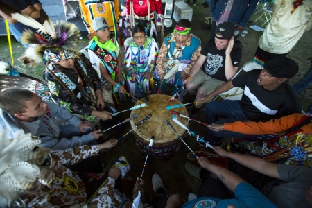 Revellers play the drum and sing during a