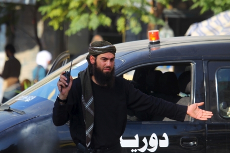 A member from a coalition of rebel groups called "Jaish al Fateh," also known as Army of Fatah" (Conquest Army), controls the traffic in Idlib city, Syria, November 7, 2015.