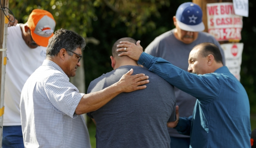 Neighbours comfort Jose Gonzales (centre), who was prevented from returning to his wife and his home at the scene of the investigation around the area of the SUV vehicle where two suspects were shot by police following a mass shooting in San Bernardino, California, December 3, 2015.