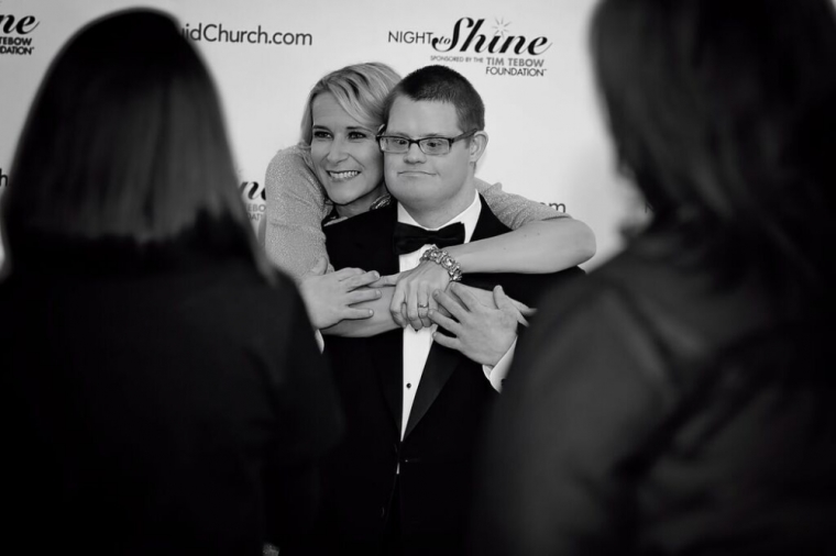 A guest and "buddy" pose for cameras on the red carpet at the Night to Shine prom event co-hosted by Liquid Church and sponsored by the Tim Tebow Foundation, Morristown, New Jersey, February 13, 2015.