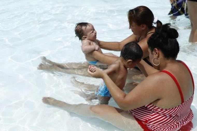 Women sit with their babies in the water during a heat wave at the Astoria Park Pool, New York, July 21, 2011. | (Photo: REUTERS/Lucas Jackson)