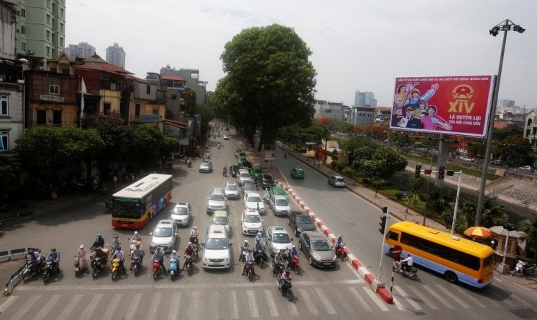 Commuters stop near a poster promoting the 14th National Assembly election on a street in Hanoi, Vietnam May 20, 2016. Communist Vietnam holds its five-yearly day of democracy on Sunday with an election for its parliament, and the only national poll in a country tightly controlled by one party for 41 years. The secretive Communist Party has been on a publicity blitz to showcase its democratic credentials, with the rural roads and the streets of its bustling cities festooned with billboards of a hammer and sickle and the workers, farmers and soldiers synonymous with the stateÕs socialist foundations. The poster reads: