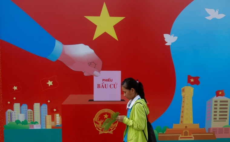A girl walks past a poster promoting the 14th National Assembly election on a street in Hanoi, Vietnam May 20, 2016. Communist Vietnam holds its five-yearly day of democracy on Sunday with an election for its parliament, and the only national poll in a country tightly controlled by one party for 41 years. The secretive Communist Party has been on a publicity blitz to showcase its democratic credentials, with the rural roads and the streets of its bustling cities festooned with billboards of a hammer and sickle and the workers, farmers and soldiers synonymous with the state's socialist foundations. The words on the poster read: