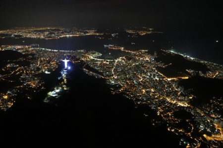 An aerial view of the Christ the Redeemer statue standing above Guanabara Bay.