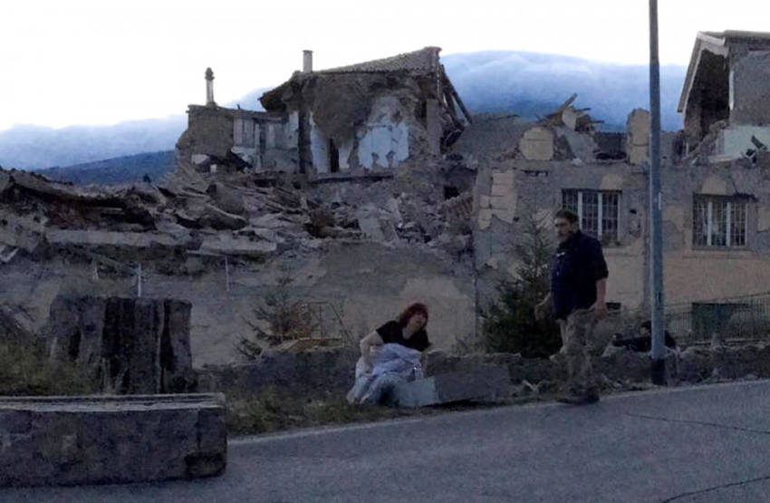 People stand by a road following a quake in Amatrice, central Italy, August 24, 2016.