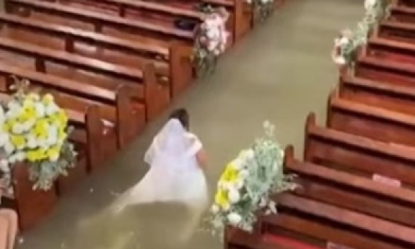 Couple marries in flooded church after monsoon in Philippines; bride walks the aisle in waist-deep water