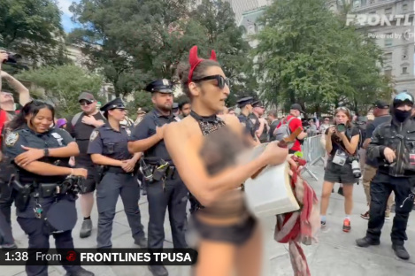 Scantily-clad trans activist wielding crucifix rips out pages of the Bible at 9/11 protest