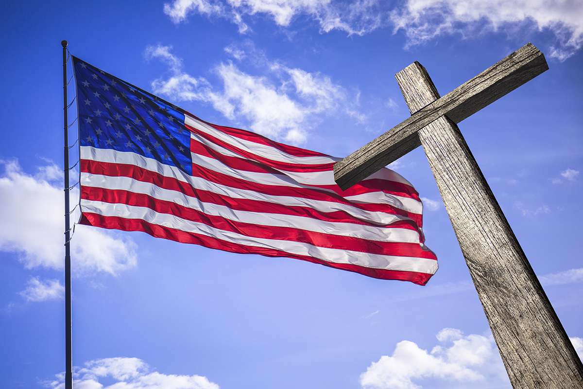American flag with a wooden cross symbolizing the intersection of Christian faith and American national identity as examined in CNN documentary The Rise of Christian Nationalism