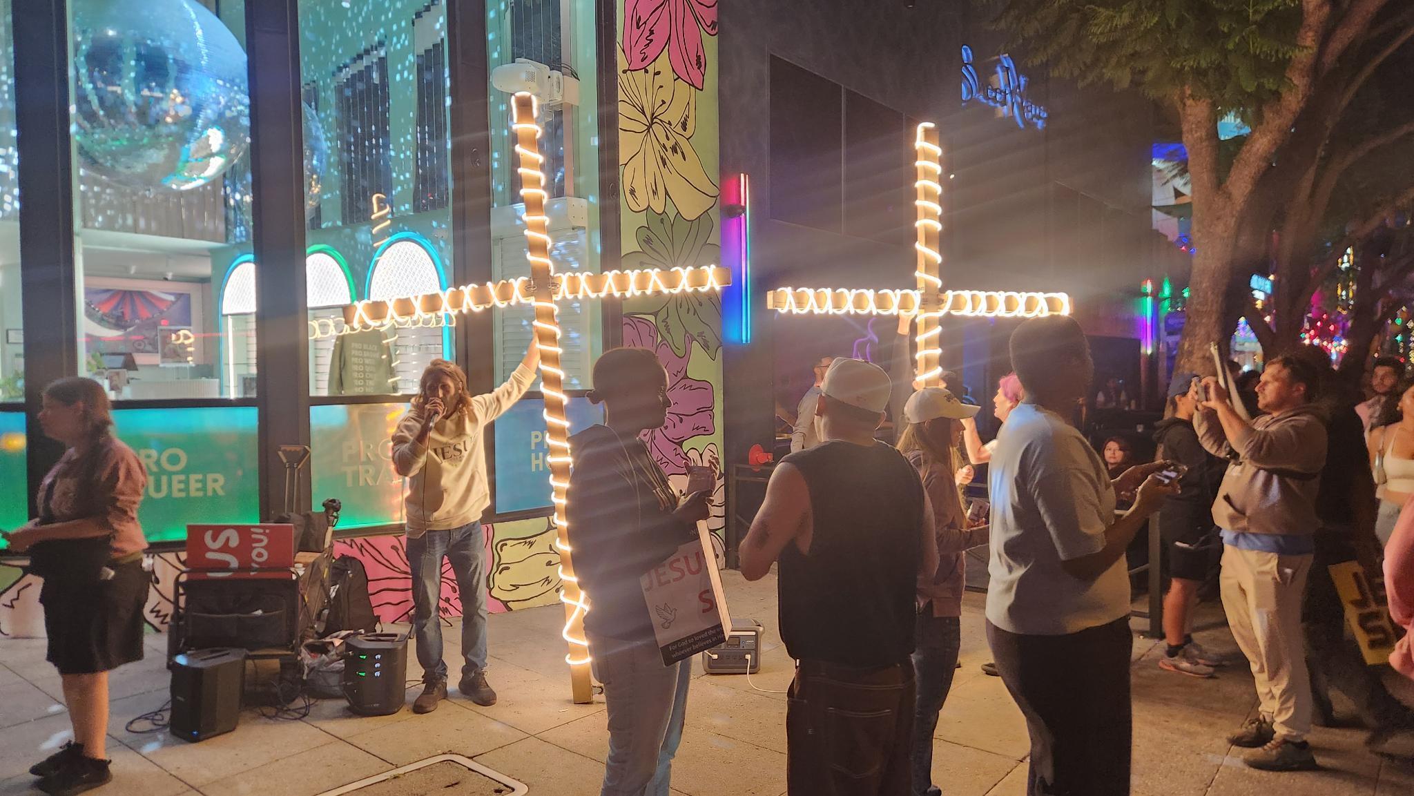 Street evangelist team assaulted by pedestrians in rainbow-painted sidewalk outside lesbian bar 
