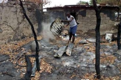 A man searches through the burnt remains of his house after it was torched during tribal clashes in the Ibi district, in the central Nigerian state of Taraba, May 1, 2004. Clashes between rival Nigerian tribes of Christians and Muslims have killed more th