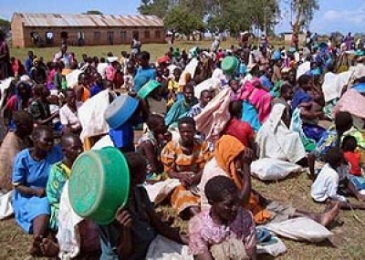 Internal displaced Ugandans wait for food distribution with empty bags and buckets at Agweng camp in Lira, northern Uganda March 4, 2005 as supplies are delivered by a Baptist mission. Some 1.6 million people, forced into camps by the war, face serious fo