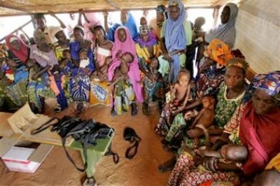 Women and their malnourished children await treatment at a make shift feed center at the town of Maradi, Niger on Sunday, July 31, 2005. Hunger is perennially a problem in Niger. But a locust invasion last year followed by drought have made the problem wo