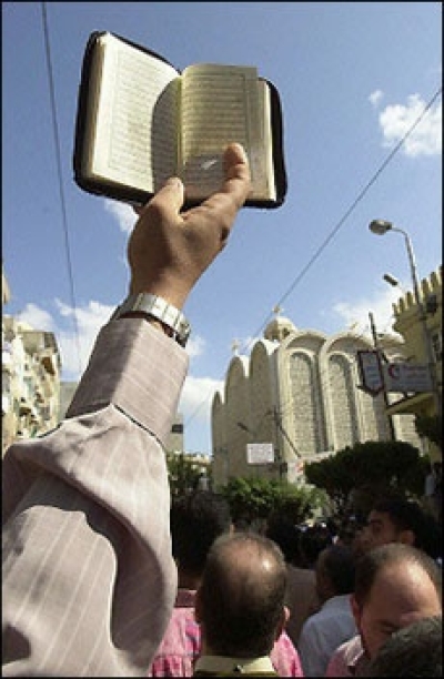 An Egyptian brandishes a Koran during a march on the Saint Girgis church in Alexandria. The usually peaceful Egyptian city of Alexandria was reeling from riots that left three dead and pitted police and Muslims protesting a play they charge is offensive t