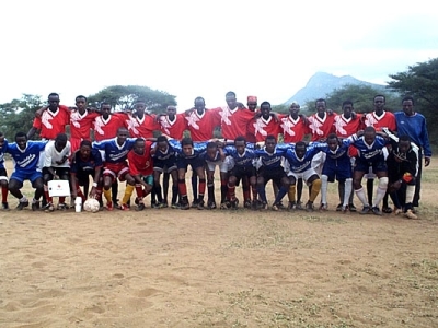 Young tribal teams play soccer as many watch on from the sideline (Photo: New Directions International)
