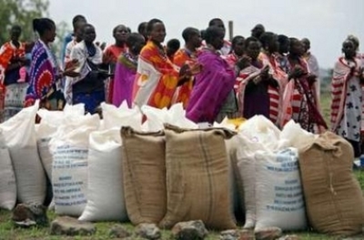 Maasai women sing and pray near sacks of food aid received from an agency as they wait for the distribution in their community near Isinya in Kenya, after a long period of drought March 7, 2006. East Africa is suffering its worst drought for years, threat
