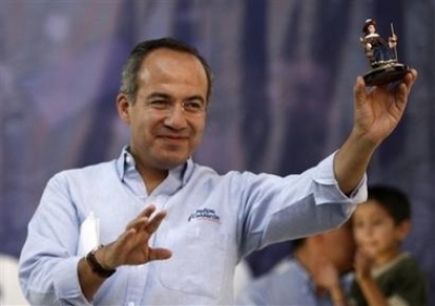Mexican presidential candidate Felipe Calderon of the National Action Party (PAN) holds a statuette of El Santo Ni