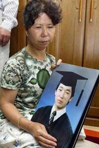 A family-friend holds up a picture of 33-year-old Kim Sun-il, known to be a 'devout Christian', and had hoped to be Christian missionary in the Arab world.