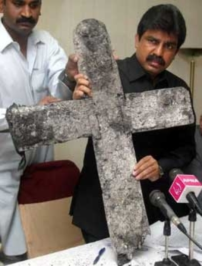 Shahbaz Bhatti (R), chairman of the All Pakistan Minorities Alliance, shows a cross which was burned during an attack on a church in central Punjab province on Saturday during a news conference in Islamabad Nov. 14, 2005. (Photo: Reuters/Faisal Mahmood)