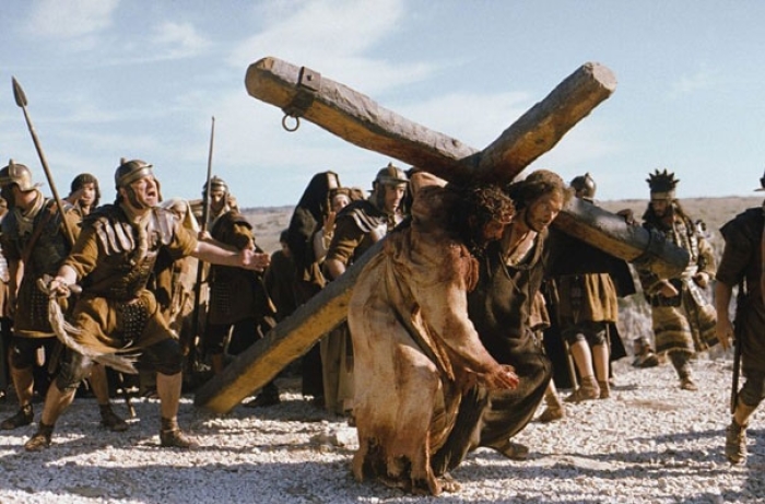 Jim Caviezel, portraying Jesus Christ, is helped by Jarreth Merz, who plays Simon of Cyrene, in carrying a cross in this scene from ''The Passion of the Christ.'' Mel Gibson's ''Passion'' ranks as the most controversial film of all time, according to Ente