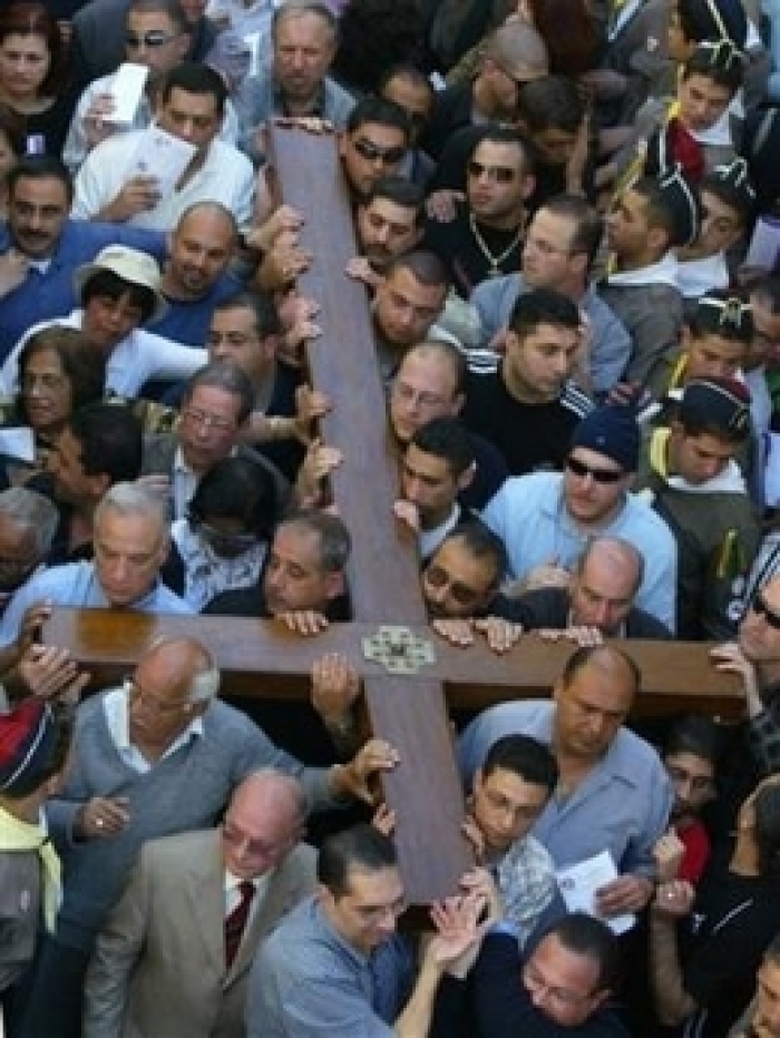 Christian pilgrims carry a large wooden cross along Via Dolorosa towrds the Church of the Holy Sepulchre retracing Jesus Christ's steps toward his crucifixion during a Good Friday procession in Jerusalem Friday, April 14, 2006. (Photo: AP / Baz Ratner)