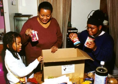A family joyfully opens a ''Box of Love'' from Here's Life Inner City, an inner city ministry that is serving hundreds of thousands of families nationwide this Thanksgiving holiday. (Photo: Demossnewspond)