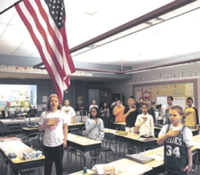 SALUTING OLD GLORY: Cathy Devlin's fourth-grade class at the Bailey International School including, front from left, Christine Long, Annieda Choup and Jake Kendal Maloney recite the Pledge of Allegiance yesterday.SUN / JAMIE LYN GIAMBRONE