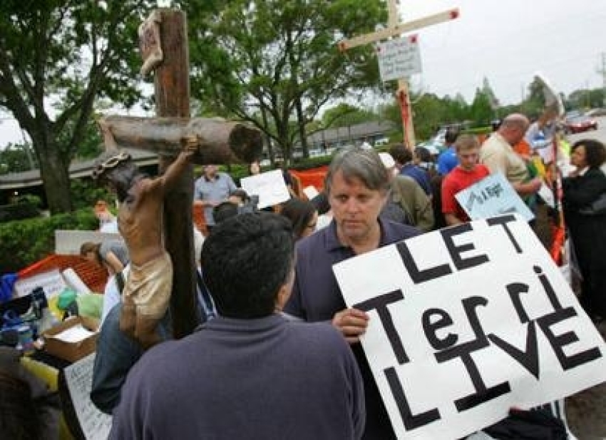 Protesters stand in front of the Woodside Hospice where brain-damaged Florida woman Terri Schiavo is being cared for, in Pinellas Park, Florida, March 23, 2005. REUTERS/Carlos Barria 