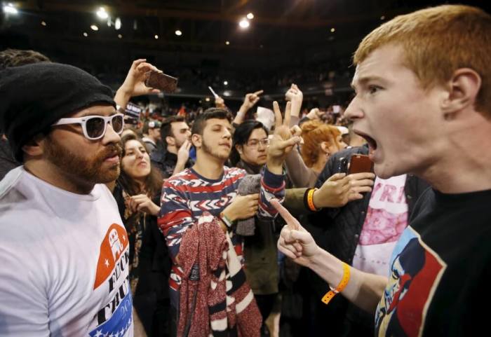 A Trump supporter (R) yells at a demonstrator (L) after Republican U.S. presidential candidate Donald Trump cancelled his rally at the University of Illinois at Chicago March 11, 2016.