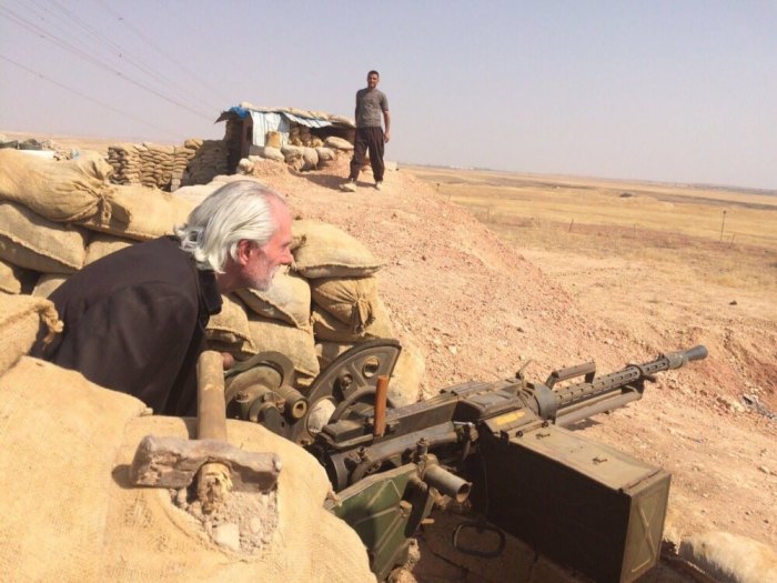 Bronx Pastor Bill Devlin sits behind a Kurdish Peshmerga .50-caliber machine gun on the Syria-Iraq border only a half mile from ISIS.