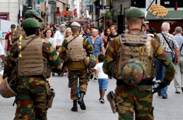Belgian soldiers patrol on a square after a man was seen wearing a thick coat with wires protruding from underneath in central Brussels, July 20, 2016.