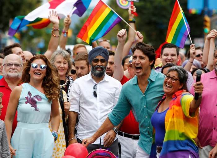 Canada's Prime Minister Justin Trudeau reacts as he and his wife Sophie Grégoire Trudeau (L) walk in the Vancouver Pride Parade in Vancouver, British Columbia, July 31, 2016.