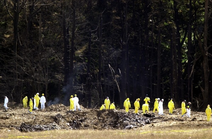 Investigators comb the debris field for the flight data recorders from United Airlines Flight 93 near Shanksville, Pennsylvania in this September 12, 2001 file photo.