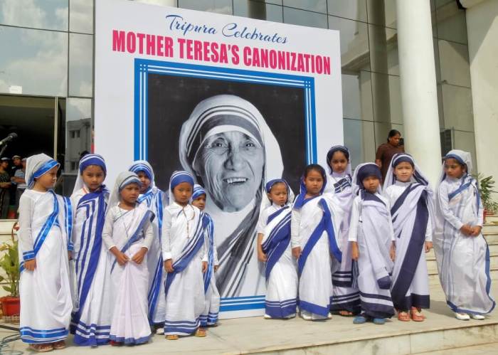Schoolgirls pose in front of a portrait of Mother Teresa during a peace rally to celebrate Mother Teresa's canonisation, in Agartala, India, September 10, 2016.