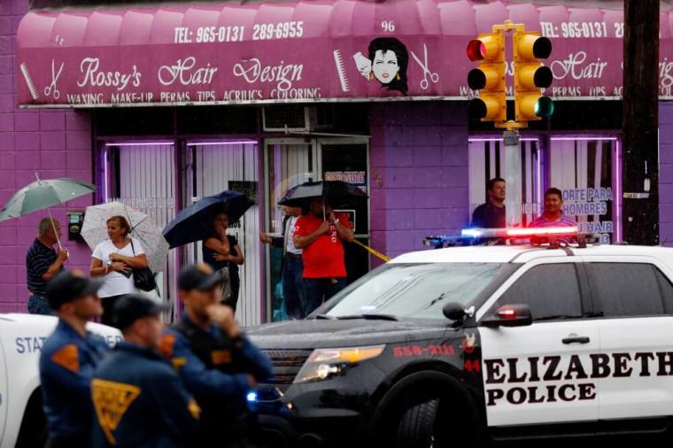 Onlookers watch while FBI personnel search an address during an investigation into Ahmad Khan Rahami, who was wanted for questioning in an explosion in New York, which authorities believe is linked to the explosive devices found in New Jersey, in Elizabeth, September 19, 2016.